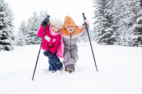 Kinder beim Winterwandern durch die verschneite Winterlandschaft